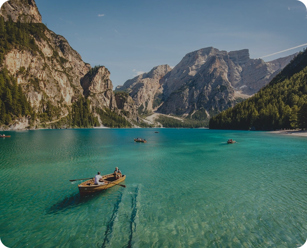 Travellers rowing on an alpine lake, a destination sold through travel platforms AppMatic Tech builds