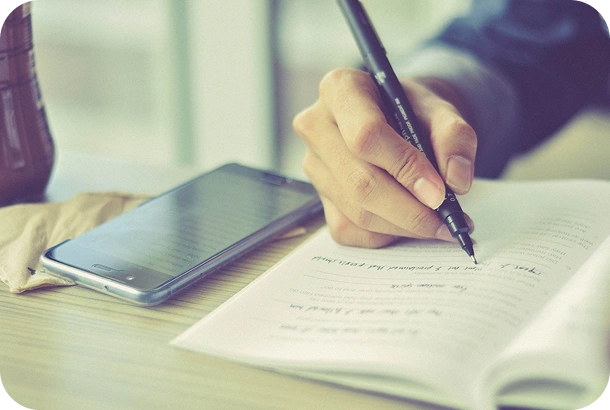 Language learner practising with FELA notebook and phone