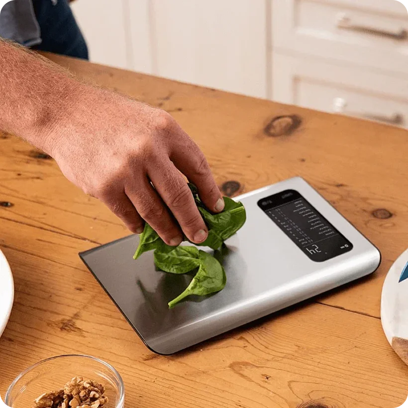 Trackwel user placing fresh ingredients on the BLE kitchen scale