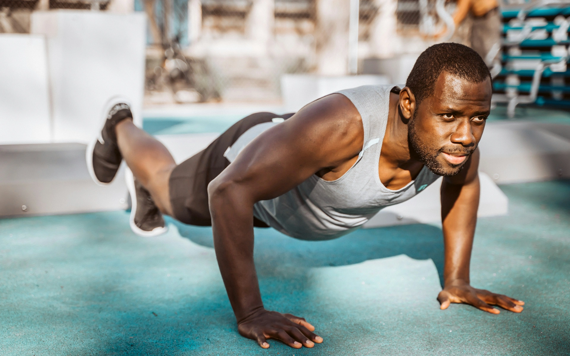 Athlete performing a push-up during an outdoor strength workout, representing the guided training the AppMatic Tech social fitness app supports